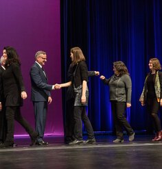 LAF staff walk across the stage to receive an Honor Award in Research