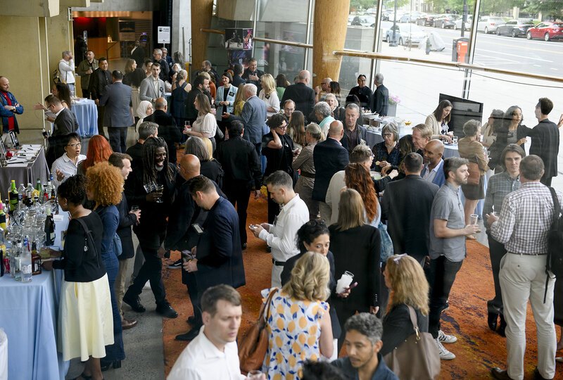 Looking down on a crowd of reception attendees in the glass-sided lobby of the theater