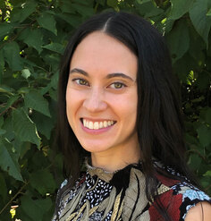 Headshot of Elizabeth Chong Baskerville smiling in front of greenery
